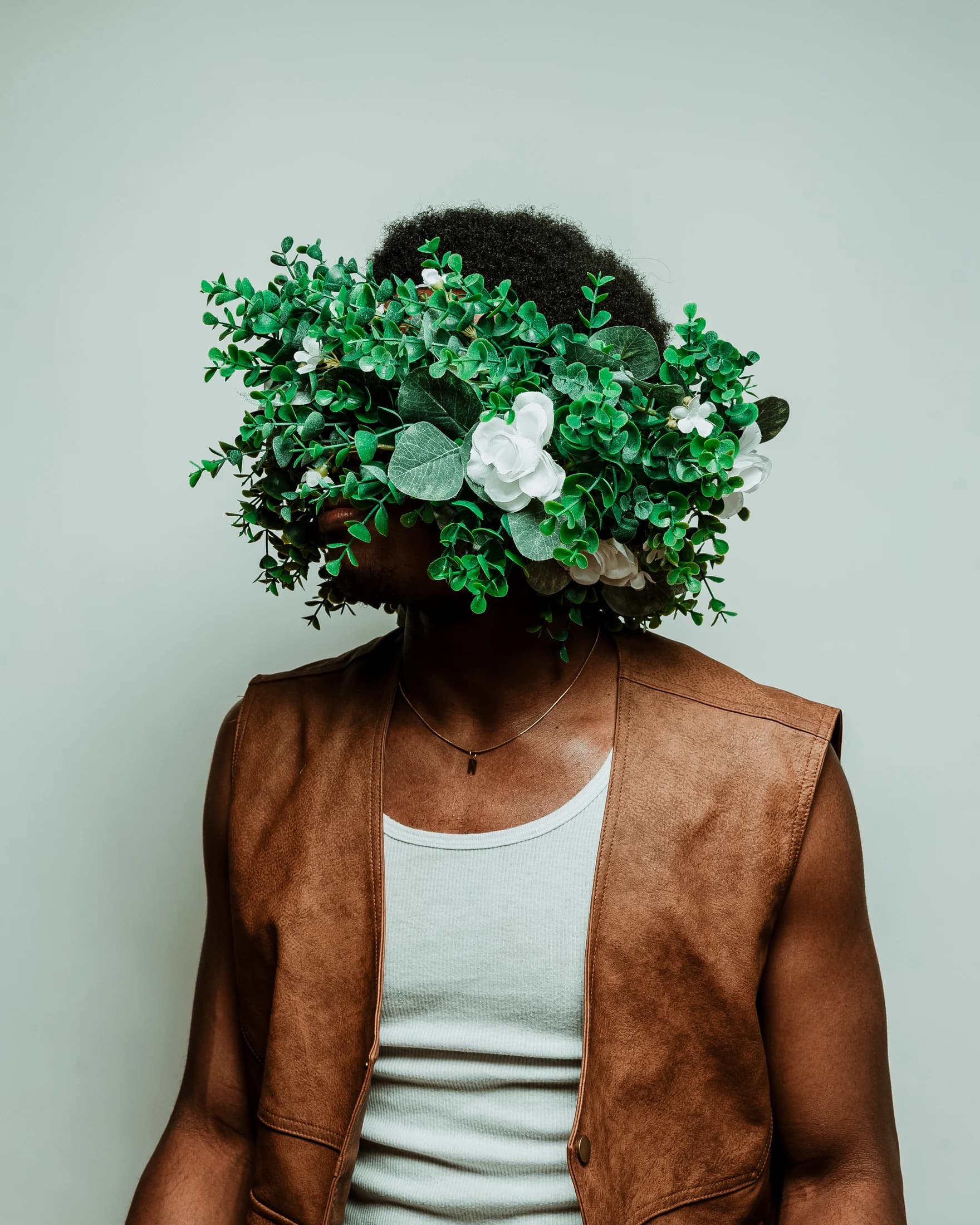 Niyi Adeogun with a sculptural arrangement of foliage and flowers obscuring his face